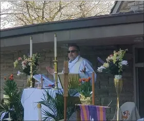  ?? ANDREW KULP — MEDIANEWS GROUP ?? Jim Farnsworth, pastor at St. Mark’s Lutheran Church in Birdsboro, stands at a makeshift altar in front of the building to deliver an Easter Sunday sermon.