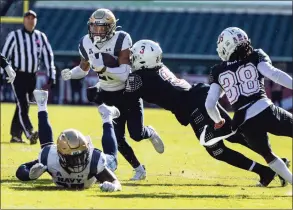  ?? Tyger Williams / Associated Press ?? Temple safety Amir Tyler (3) takes down Navy fullback Carlinos Acie (25) during the first half on Nov. 27.