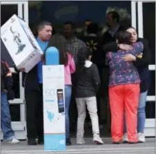  ?? DAVID ZALUBOWSKI — THE ASSOCIATED PRESS ?? Marlena Fobb, front right, of Thornton, Colo., who was shopping at the time of the shooting at a Walmart store, hugs an unidentifi­ed store employee Thursday in Thornton, Colo. The store was the scene of a shooting Wednesday night when a man walked in...