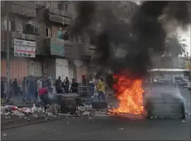  ?? HADI MIZBAN — THE ASSOCIATED PRESS ?? Anti-government protesters set fire and block roads in Baghdad, Iraq, on Wednesday. Security forces fired in the air and used tear gas Wednesday to disperse protesters.