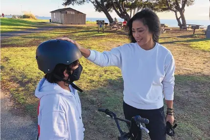  ?? HAVEN DALEY/ASSOCIATED PRESS ?? Keryn Francisco spends time with her 10-year-old son Reve Francisco learning how to ride a bicycle in Alameda, Calif., on Tuesday. As the U.S. economy rebounds from the ongoing pandemic, many women are choosing to sit out the labor force. During her time away from work, Francisco made a discovery that hadn’t quite seemed clear to her before: “I was burned out. I used to think that work-life balance was such a fantasy.” Now, she’s considerin­g the conditions for a full-time return to the workforce.