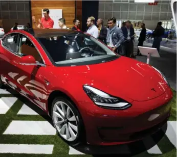  ?? PATRICK T. FALLON/BLOOMBERG ?? The pressure is on Elon Musk to see if Tesla can mass produce its Model 3 vehicles.