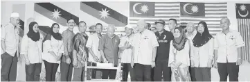  ??  ?? Morshidi cuts the anniversar­y cake, witnessed by members of the organising committee of the event at Kampung Malaysia Jaya community hall.