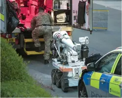  ??  ?? Drama: Bomb squad personnel deploying a ‘robot’, used to deal with explosive devices, in Blantyre last night