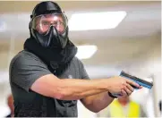  ??  ?? A designated shooter moves down a hallway at Norman Regional Hospital during an armed intruder drill that involved police, first responders and medical personnel.