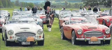  ?? Picture: Perthshire Picture Agency. ?? Atholl Highlander­s Pipe Major Ian Duncan plays as hundreds of Austin Healeys gather at Bruar, near Blair Atholl.