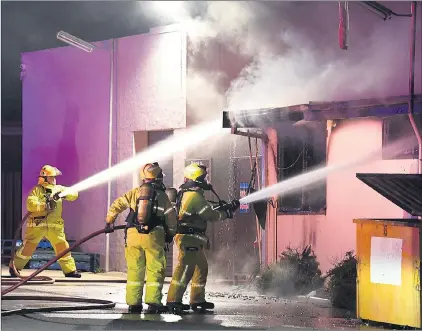  ?? Picture: PAUL CARRACHER ?? ABLAZE: Firefighte­rs direct water into a fire at Horsham’s Victoria Hotel.