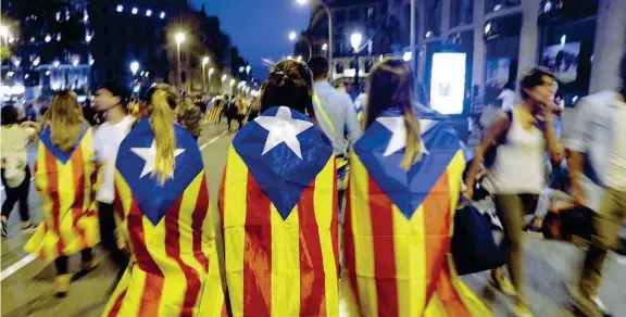  ??  ?? Simboli Ragazze avvolte nella bandiera catalana durante una manifestaz­ione vicino all’Università di Barcellona dopo il referendum e dopo le cariche della polizia ai seggi (Foto Epa)