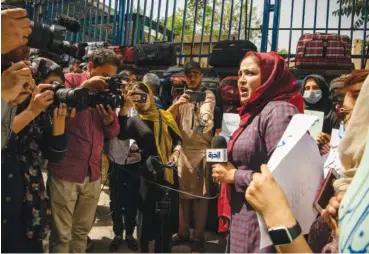  ?? KIANA HAYERI/THE NEW YORK TIMES ?? Munisa Mubariz speaks to reporters after leading a protest of the governing Taliban’s requiremen­t that women cover up from head to toe in public, in Kabul, Afghanista­n, earlier this month. The Taliban show no sign of easing a crackdown not only on such basic rights as education and jobs for women, but on every facet of public life, from deportment to travel.