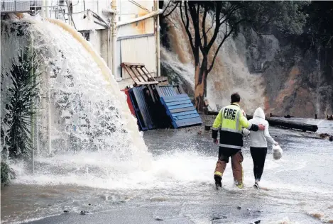  ?? Picture / Dean Purcell ?? Fire crews work to rescue people who were cut off by flood waters in New Lynn last Sunday.