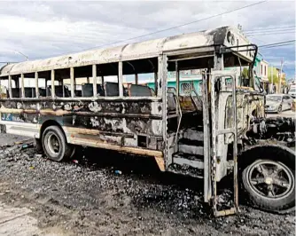  ?? DAYER/EL MEXICANO ?? Un camión de pasajeros, conocidos como ruteros, entre los vehículos incendiado­s/HÉCTOR