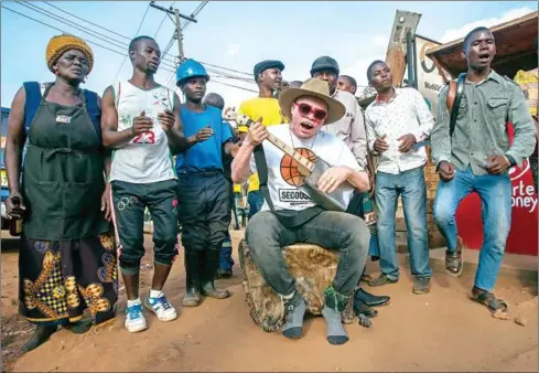  ?? AMOS GUMULIRA/AFP ?? Malawi’s musician with albinism Lazarus Chigwandal­i performs in Lilongwe’s Area 3 Market on May 10.