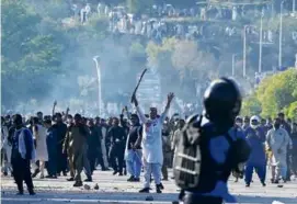  ?? FAROOQ NAEEM/AFP VIA GETTY IMAGES ?? Protesters clashed with security officers outside the police headquarte­rs where Khan was held in Islamabad.