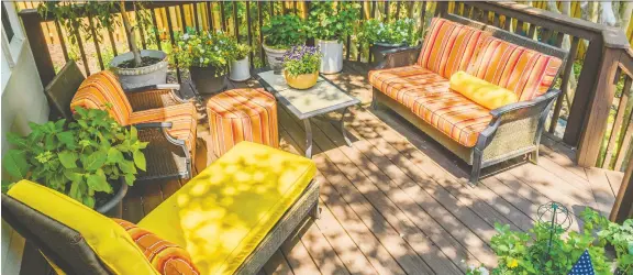  ??  ?? Colourful cushions and comfy furniture will make a deck a favourite spot to pass a shady afternoon on a summer day. If you have room for a fire pit, enjoy s’mores as the sun sets.