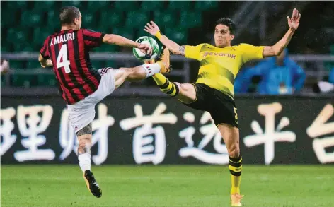  ?? FOTO: REUTERS ?? Schaulaufe­n in Guangzhou: José Mauri (li.) vom AC Mailand und Marc Bartra (Borussia Dortmund) beim Spitzentan­z.