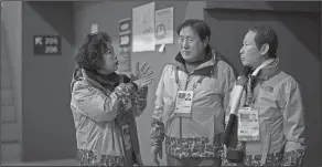  ?? Associated Press ?? Volunteers: Sohn Yang Young, right, and Lee Gyeong Pil, center, talk with Ock Junghee after arriving in the Gangneung Curling center at the 2018 Winter Olympics in Gangneung, South Korea, Saturday. Sohn and Lee were among five babies born on an...