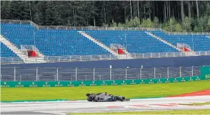  ?? AFP ?? Mercedes’ Lewis Hamilton steers his car past empty stands during the first practice session at the Austrian Grand Prix yesterday.