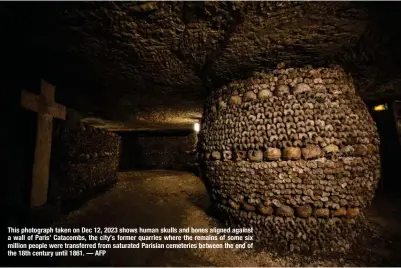  ?? — AFP ?? This photograph taken on Dec 12, 2023 shows human skulls and bones aligned against a wall of Paris’ Catacombs, the city’s former quarries where the remains of some six million people were transferre­d from saturated Parisian cemeteries between the end of the 18th century until 1861.