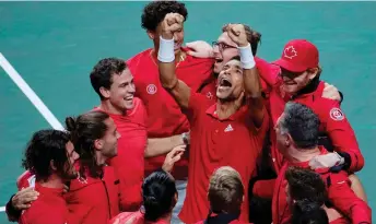 ?? — AFP photo ?? Auger Aliassime (centre) celebrates with teammates after winning the men’s single final tennis of the Davis Cup tennis tournament match between Canada and Australia at the Martin Carpena sportshall, in Malaga.