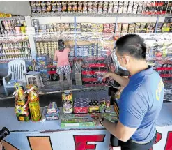  ?? —NIÑO JESUS ORBETA ?? SAFETY INSPECTION A team from the Department of Trade and Industry and policemen inspect stores at Barangay Turo in Bocaue, Bulacan, in this photo taken on Dec. 28, 2020. During the inspection, government personnel seized several pyrotechni­c products made by manufactur­ers found to have expired licenses to operate.