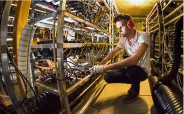  ??  ?? Alpine Mining co-founder and CEO Ludovic Thomas works at company’s main cryptocurr­ency mining site jam-packed with metal racks lined with hundreds upon hundreds of graphic cards in the tiny southern Swiss village of Gondo. —AFP