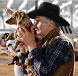  ?? Michael Wyke ?? An owner gives a pep talk to his dog before putting it into the starting gate for the first heat during the 11th annual Wiener Dog Races that take place between horse races at Sam Houston Race Park.