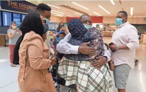  ?? PHOTOS BY DORAL CHENOWETH/COLUMBUS DISPATCH ?? Mohamed Salem Ali gets a hug from wife Fadumo Hussein shortly after he arrived at John Glenn Internatio­nal Airport on Thursday.