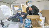  ?? AMBER ARNOLD/ASSOCIATED PRESS ?? Nursing assistant Monica Brodsky, left, and nurse Taylor Mathisen work at a drive-thru testing site for COVID-19 on Monday in Middleton, Wis.