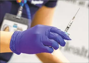  ?? NURSE EUNICE LEE Brian van der Brug Los Angeles Times ?? holds a syringe of COVID- 19 vaccine at Ronald Reagan UCLA Medical Center. Experts say the collection of personal data is crucial for safely administer­ing doses and that patients have little to fear.