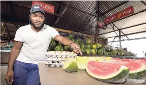  ?? TAYLOR/ PHOTOGRAPH­ER GLADSTONE ?? Marvin Rodney shows off his watermelon­s in Coronation market, downtown, Kingston.