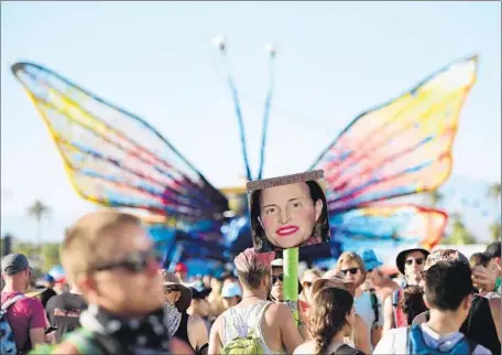  ?? Jason Kempin
Getty Images ?? A MUSIC FAN holds a placard bearing the face of gold-medal Olympian Bruce Jenner with reddened cheeks and lips during the first weekend of Coachella in Indio this month. Jenner revealed to ABC’s Diane Sawyer that he now publicly identifies as a woman.