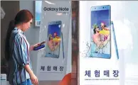  ?? JUNG YEON-JE / FOR CHINA DAILY ?? A woman walks past advertisin­g posters for Samsung in Seoul.