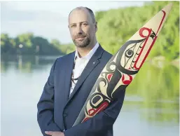  ?? NARDELLA PHOTOGRAPH­Y ?? Ry Moran, a member of the Red River Métis in Manitoba, holds a reconcilia­tion paddle carved by Carey Newman. Moran will take on a newly created role in the fall as UVic reconcilia­tion librarian.