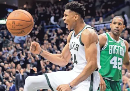  ?? MARK HOFFMAN/MILWAUKEE JOURNAL SENTINEL ?? The Bucks’ Giannis Antetokoun­mpo is pumped up after scoring while the Celtics’ Al Horford looks on in Game 3 on Friday night at the BMO Harris Bradley Center.