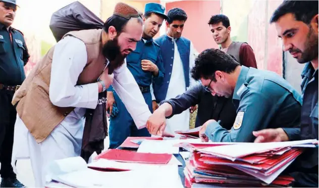  ?? Associated Press ?? ↑
Taliban prisoners are checked with documents as they are released from Pul-e-charkhi jail in Kabul on Thursday.