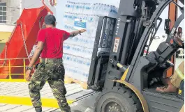  ?? CONTRIBUTE­D PHOTOS ?? Cases of water are loaded onto the vessel headed for Saint Vincent with relief supplies.