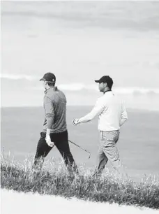  ?? ROSS KINNAIRD/GETTY ?? Former U.S. Open champs Jordan Spieth and Tiger Woods, right, take in a practice round Wednesday at Pebble Beach. The major starts Thursday.