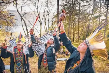  ?? JEFF J MITCHELL/GETTY ?? Indigenous people from the Amazon rainforest perform Sunday at the Cormonacha­n Woodlands, northwest of Glasgow, Scotland, site of the COP26 climate change summit. The aim of the summit, which ends Friday, is to get countries from around the world to commit to net-zero carbon emissions by 2050. Some have offered later dates.