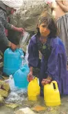  ?? ASSOCIATED PRESS FILE PHOTO ?? In 2002, Hajera, an Afghan refugee from Faryab, gets water for her family in a refugee camp in Kandahar. Now, 15 years later, the Taliban have begun to hit Faryab and other remote regions in the northweste­rn provinces again.