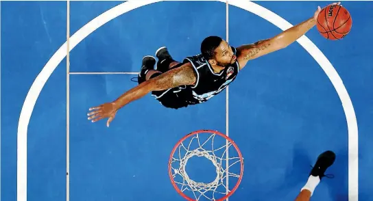  ?? PHOTOS: GETTY IMAGES ?? DJ Newbill of the Breakers grabs a rebound against the Brisbane Bullets in Auckland on Thursday night.