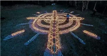  ?? GETTY ?? German Gertrud Schop lights candles on her property for all the country’s Covid-19 victims.