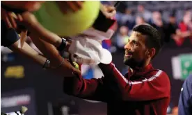  ?? Photograph: Claudia Greco/Reuters ?? Novak Djokovic signs autographs for fans shortly before being struck by a metal bottle.