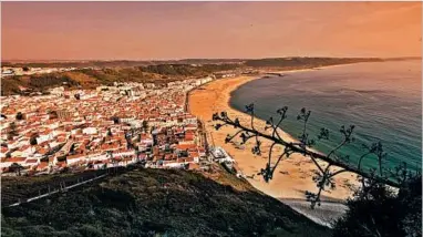  ?? DOMINIC ARIZONA BONUCCELLI/RICK STEVES’ EUROPE ?? The hillside neighborho­od of Sitio overlooks the beach in Nazare, Portugal. A funicular, built in 1889, runs from the beach to the scenic bluff.