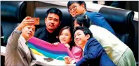  ?? PHOTO: EPA-EFE ?? Move Forward Party lawmakers take a selfie to celebrate the passage of a marriage equality bill in the Thai House of Representa­tives in Bangkok yesterday.