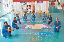  ?? AFP ?? Medical staff pose next to a design created on the floor of a hospital in Bengaluru to celebrate the milestone yesterday.