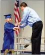  ?? Photo by Mike Eckels ?? Bryson Clayton (left) receives his diploma from principal Cary Stamps during the May 23 kindergart­en graduation ceremony in the cafeteria at Decatur Northside Elementary School.