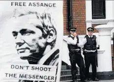  ?? Carl Court / AFP / Getty Images ?? A sign in support of Julian Assange is held in front of the Ecuadoran Embassy in London, where the WikiLeaks founder has been holed up since June.