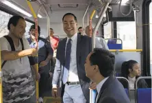  ?? Lisa Krantz / San Antonio Express-News ?? Julian Castro (center) rides the San Antonio city bus with his twin brother, Joaquin (right) to announce his presidenti­al bid.