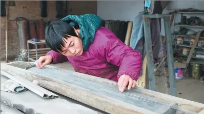  ?? LI XIUPING / CHINA DAILY ?? Xu Yachong, a resident in Lankao, Henan province, tunes a guqin, a seven-stringed Chinese instrument, in December.