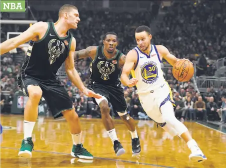  ?? Morrry Gash / Associated Press ?? Stephen Curry drives past Milwaukee’s Eric Bledsoe (6) and Brook Lopez during the first half of tbe Warriors’ win.